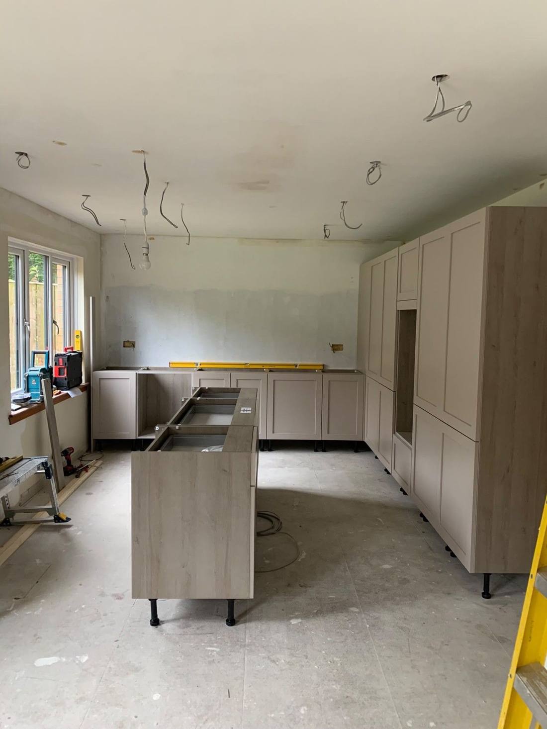 Kitchen carcasses being set out and levelled before worktops go on